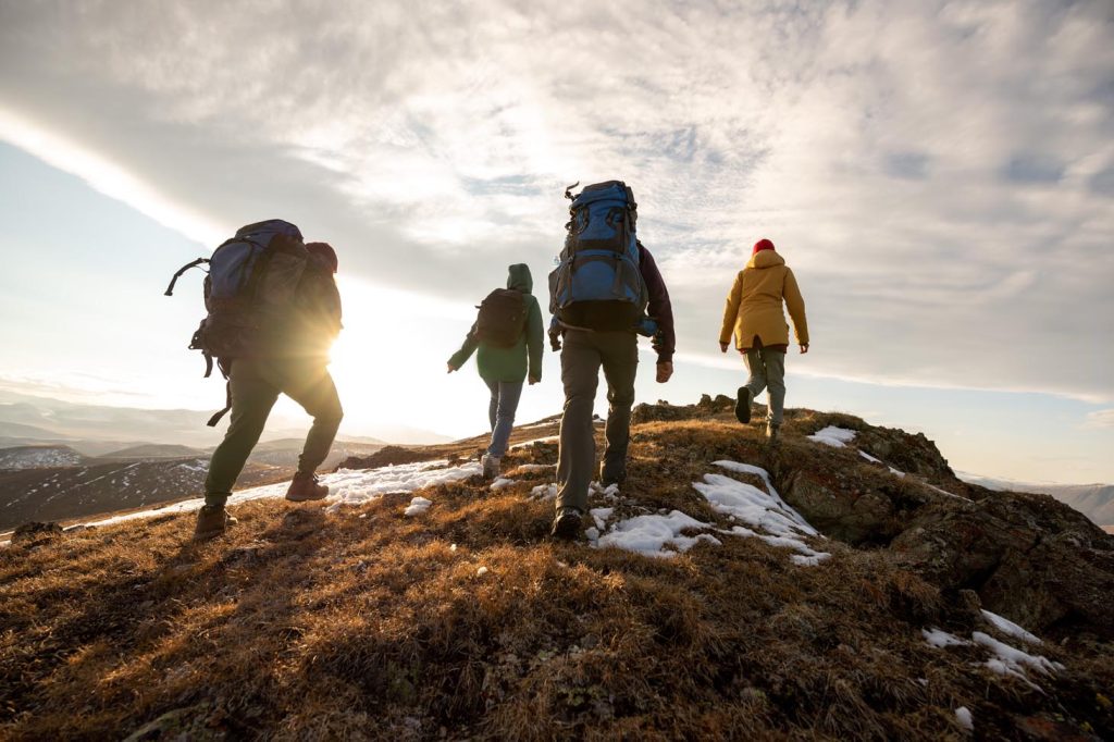 4 personnes qui marche sur une montagne en randonnée  