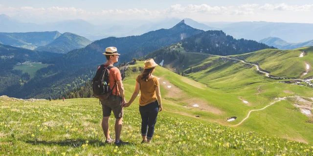 2 personnes qui se tiens la main sur une montagne en randonnéée